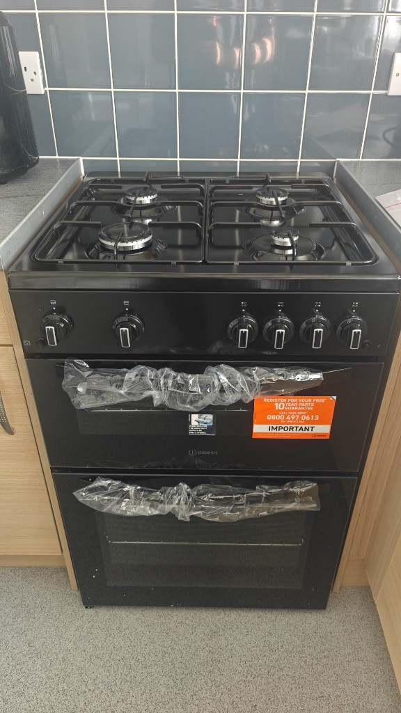 Black Indesit double oven freestanding gas cooker in a fitted kitchen