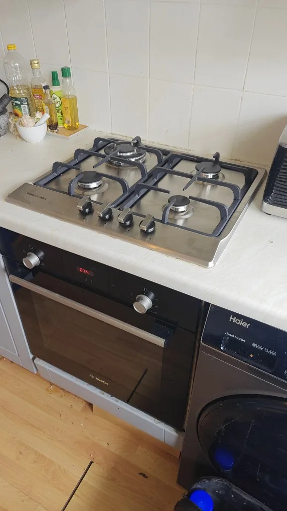 Rangemaster stainless steel four-burner gas hob installed above a Bosch built-in oven